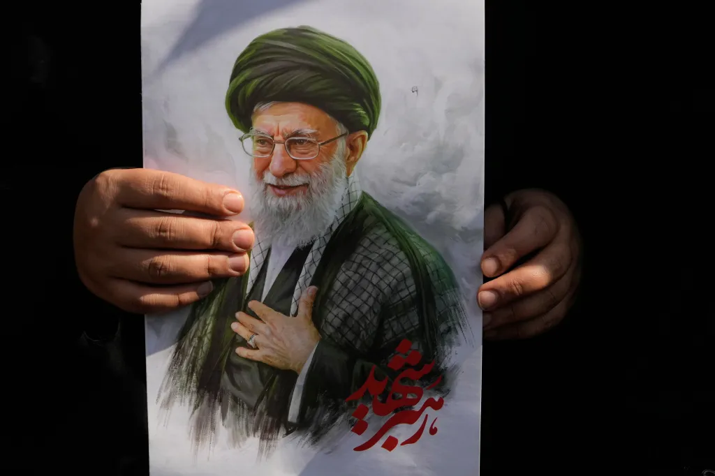 A woman holding a poster of the late Supreme Leader Ayatollah Ali Khamenei at Arbaeen rituals in Tehran.