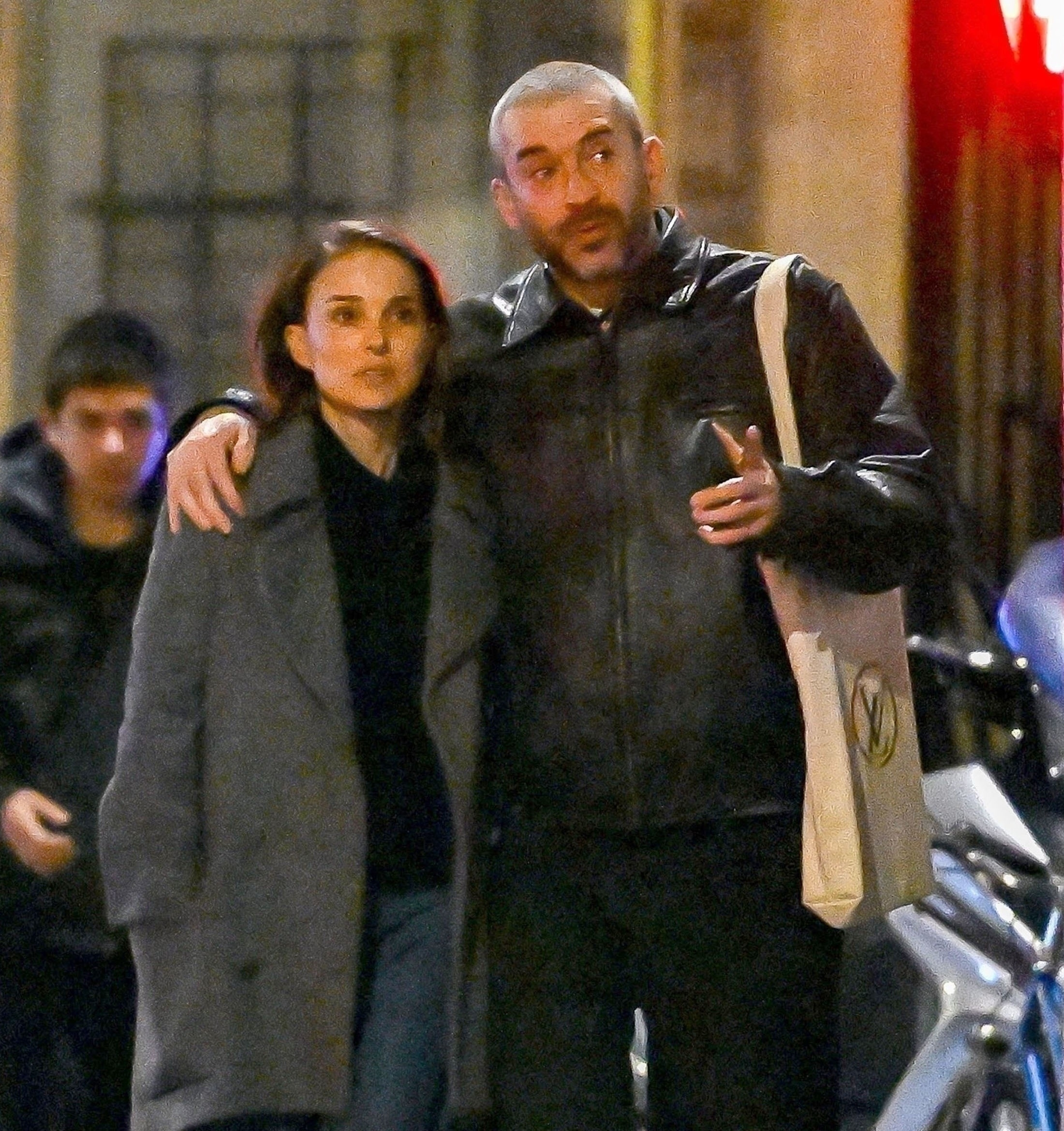 Natalie Portman and rumored boyfriend Tanguy Destable 'Tepr' walking together on the street at night, with Tanguy's arm around her shoulders.