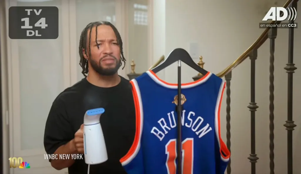Jalen Brunson holds a steamer next to a blue basketball jersey with 