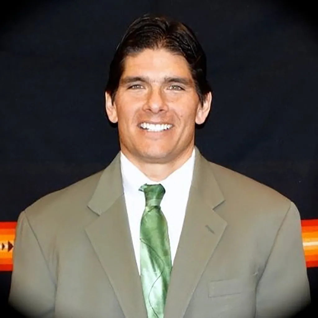 Jason Giles, Executive Director of the National Indian Gaming Association, smiling and wearing a suit and green tie.