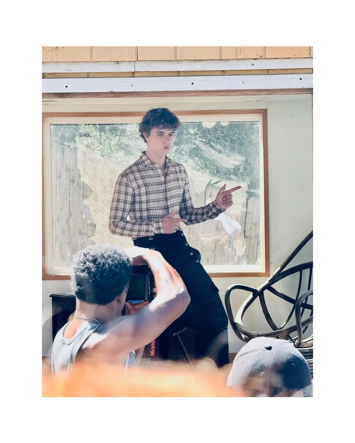 Jayden Spears in a plaid shirt pointing his finger while being photographed.