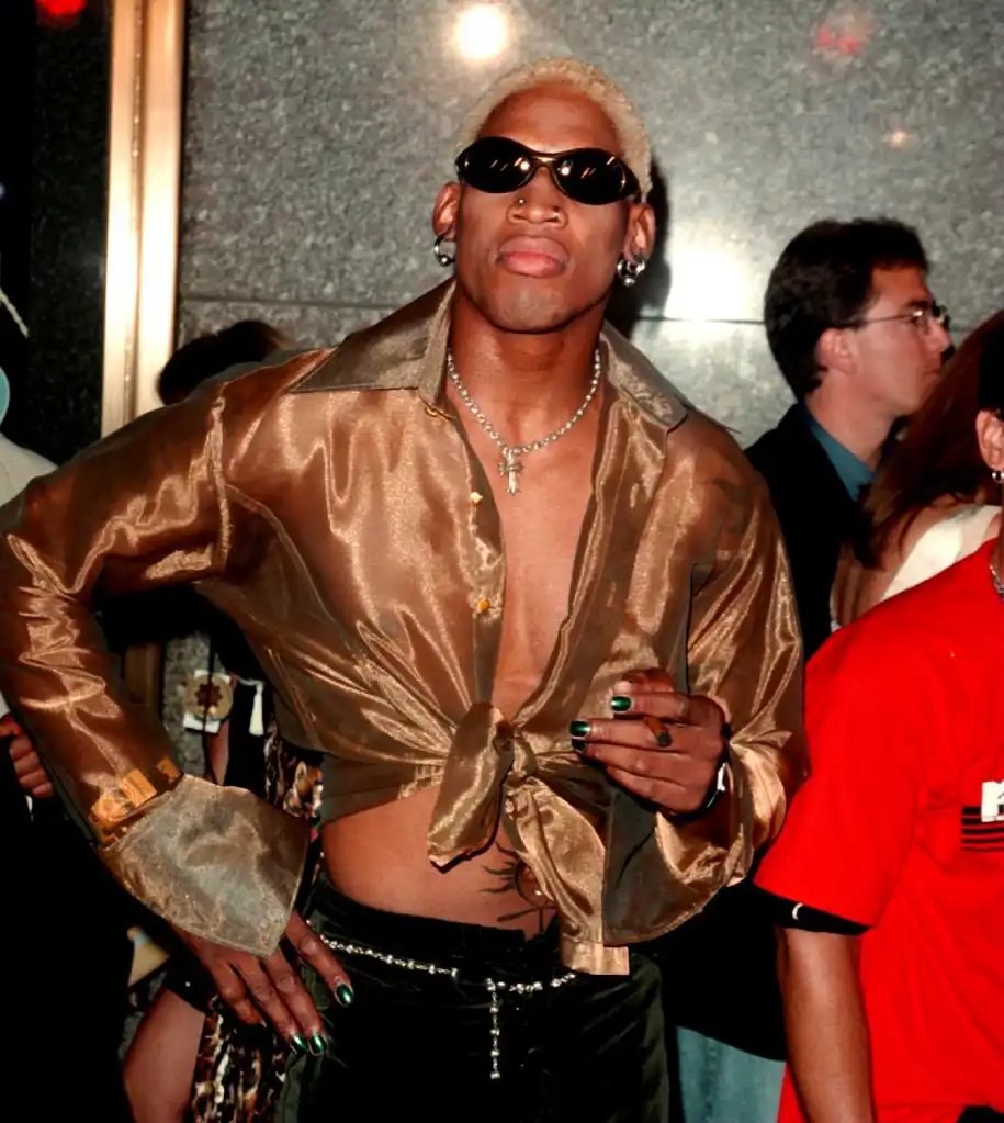 Dennis Rodman in a golden sheer shirt, dark pants, and sunglasses at the MTV Video Awards.