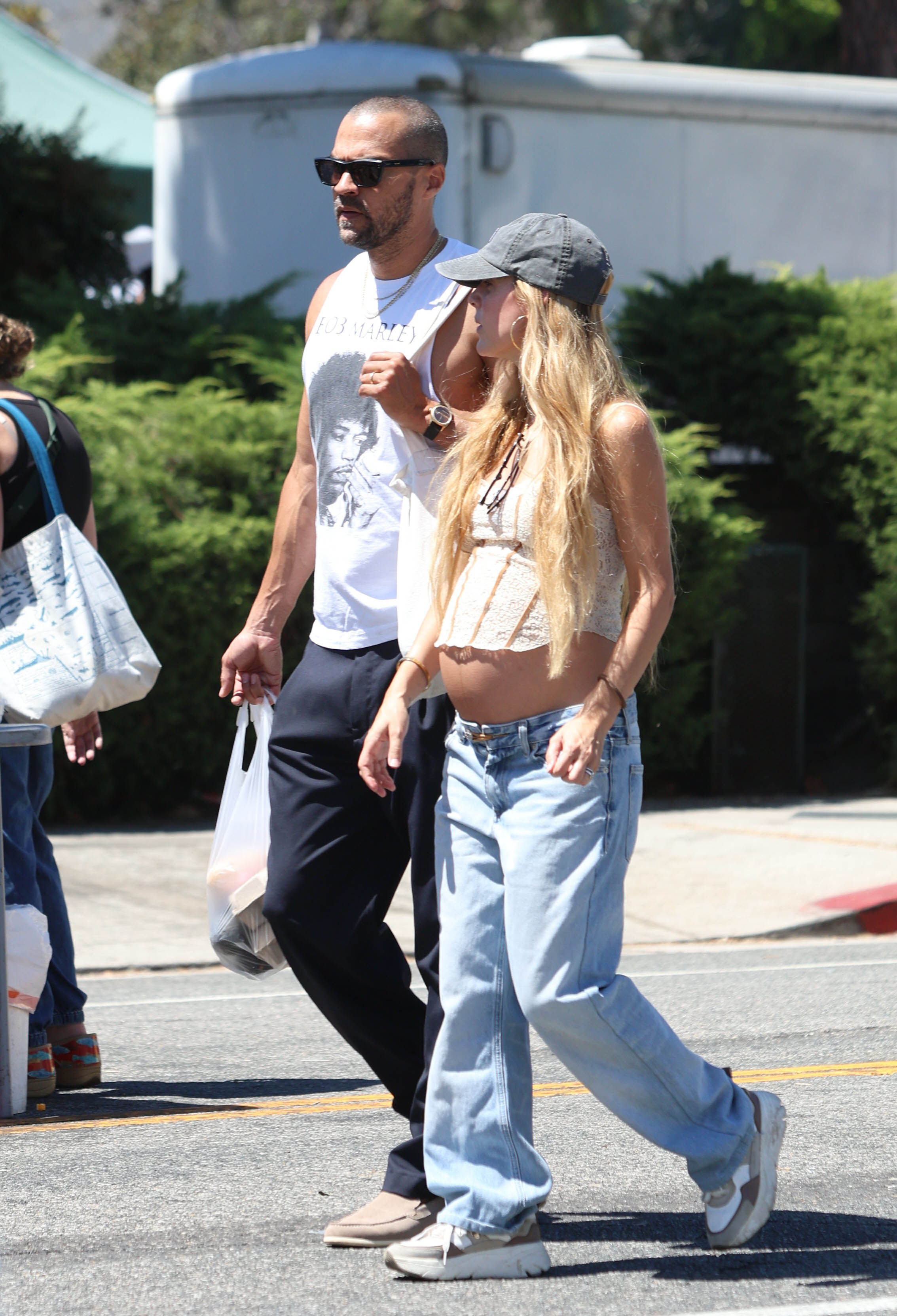 Jesse Williams and Alejandra Onieva walking at The Studio City Farmers Market.