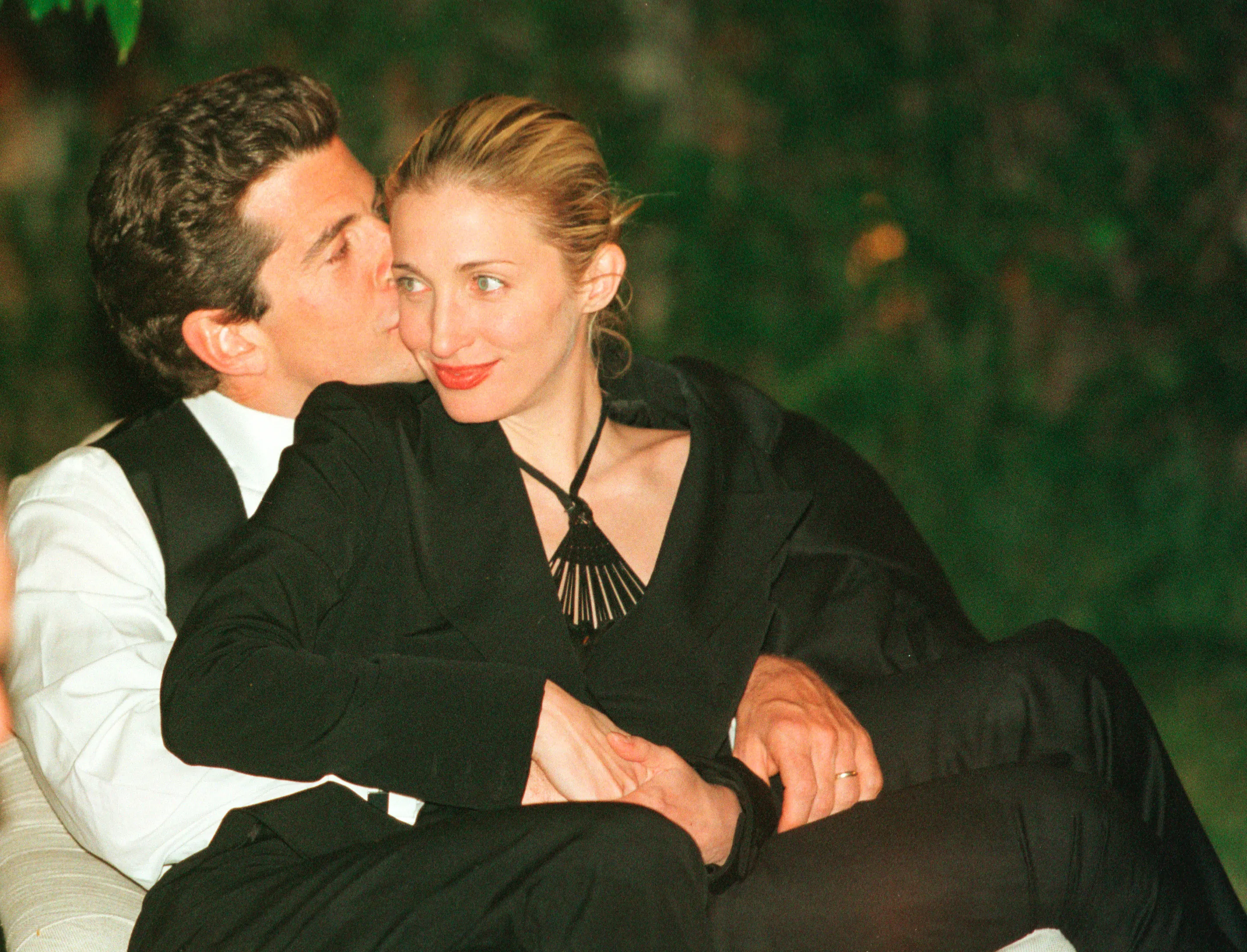 John F. Kennedy Jr. kissing his wife Carolyn Bessette-Kennedy on the cheek.