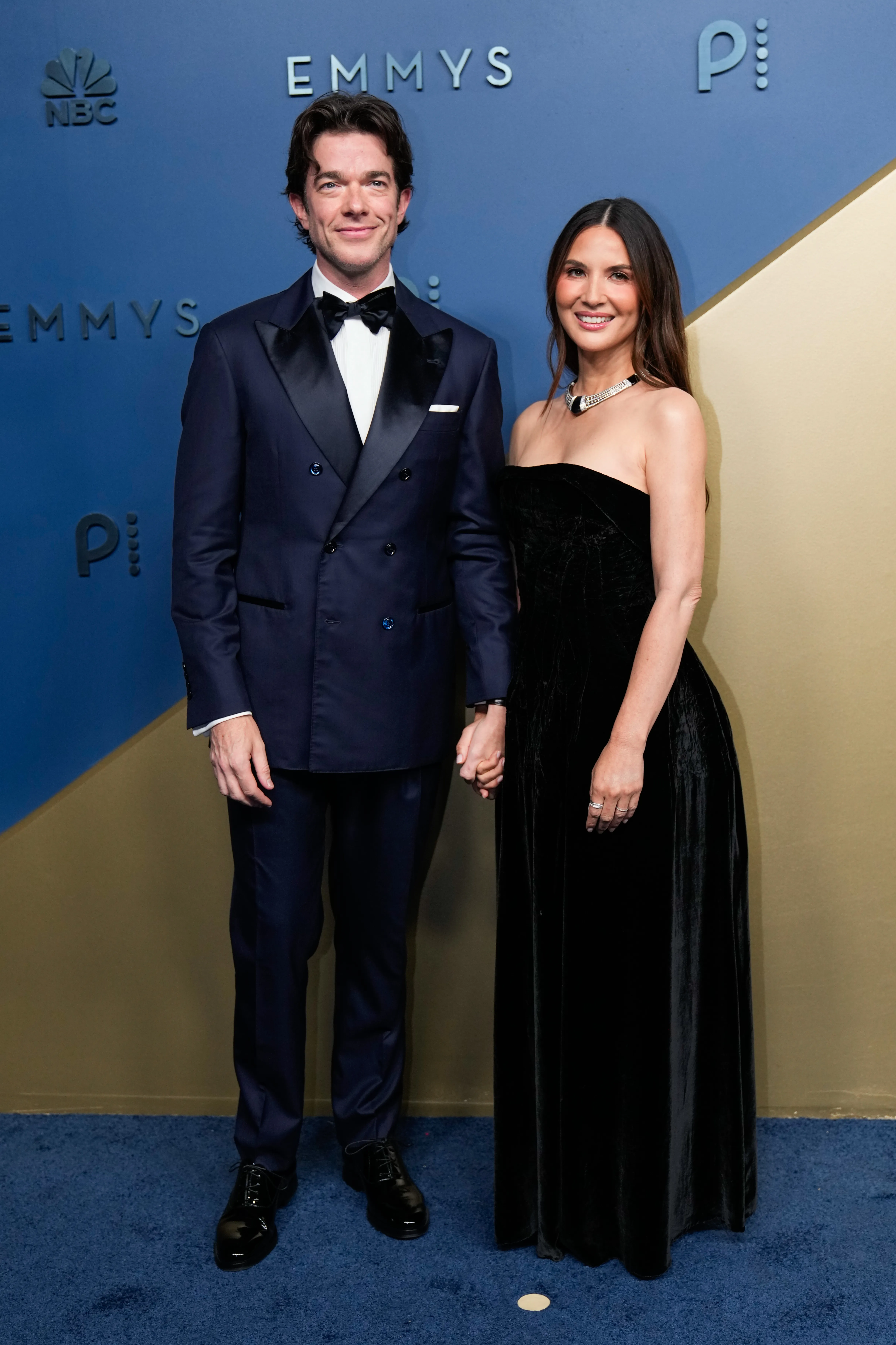 John Mulaney and Olivia Munn holding hands at the Emmys.