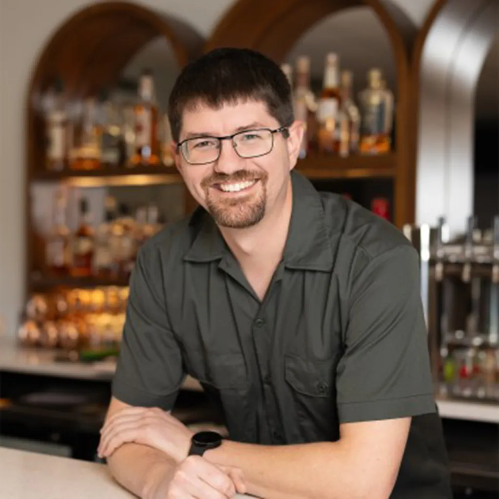 John Ream, former aerospace engineer and brewery owner, smiling at a bar.