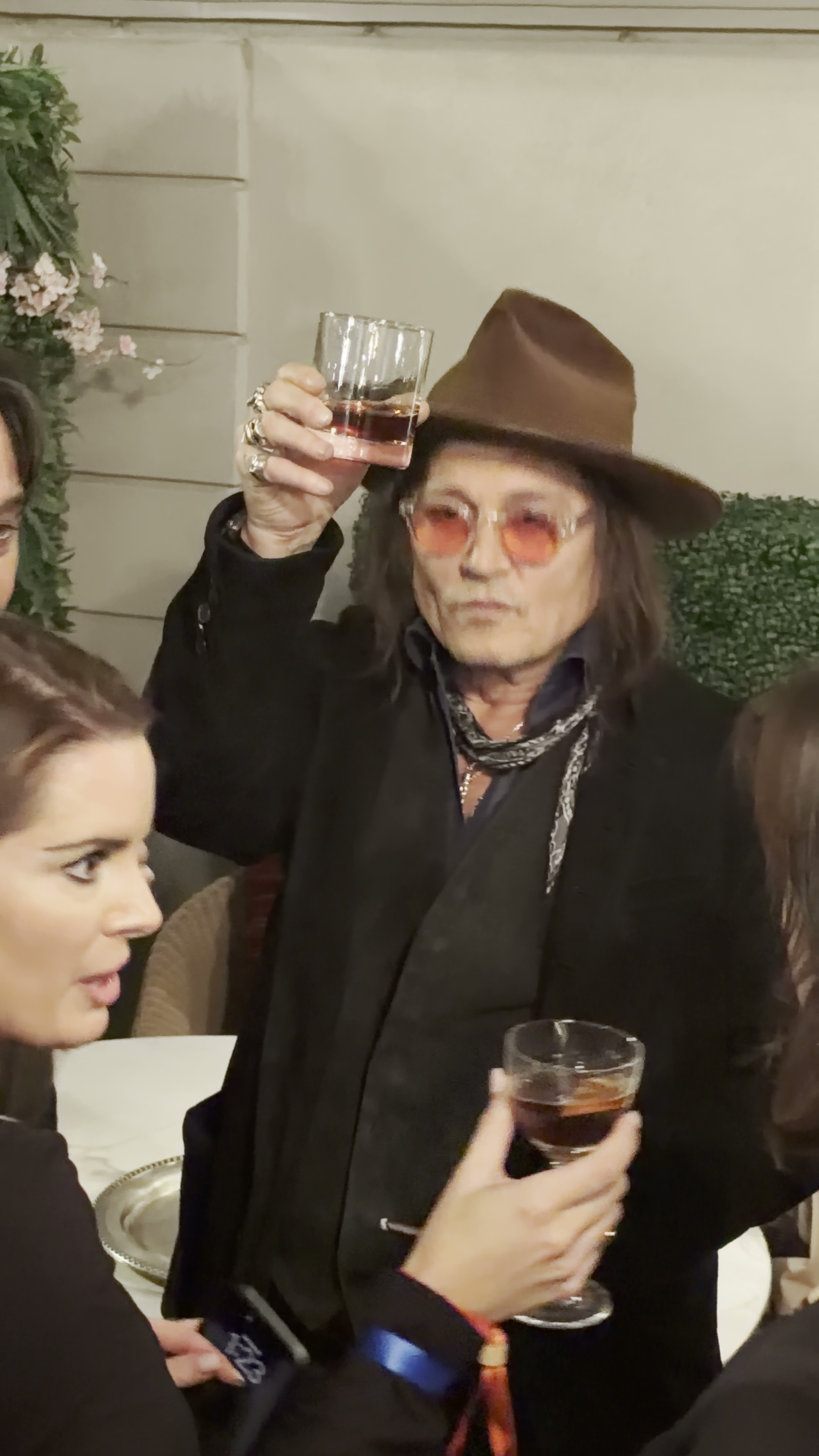 Johnny Depp raising a glass in a toast at a party.
