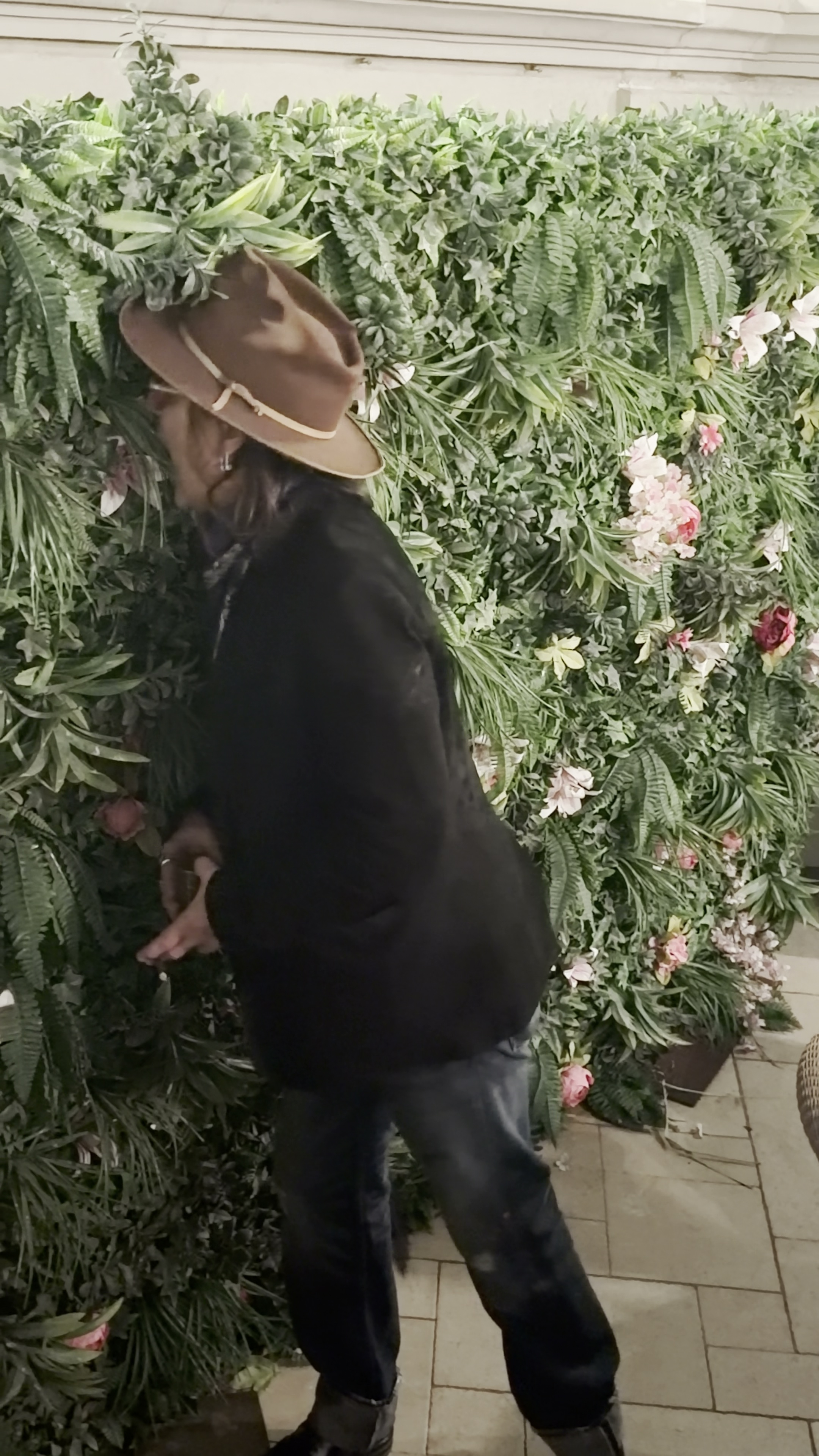 Johnny Depp eating from an artificial plant backdrop.