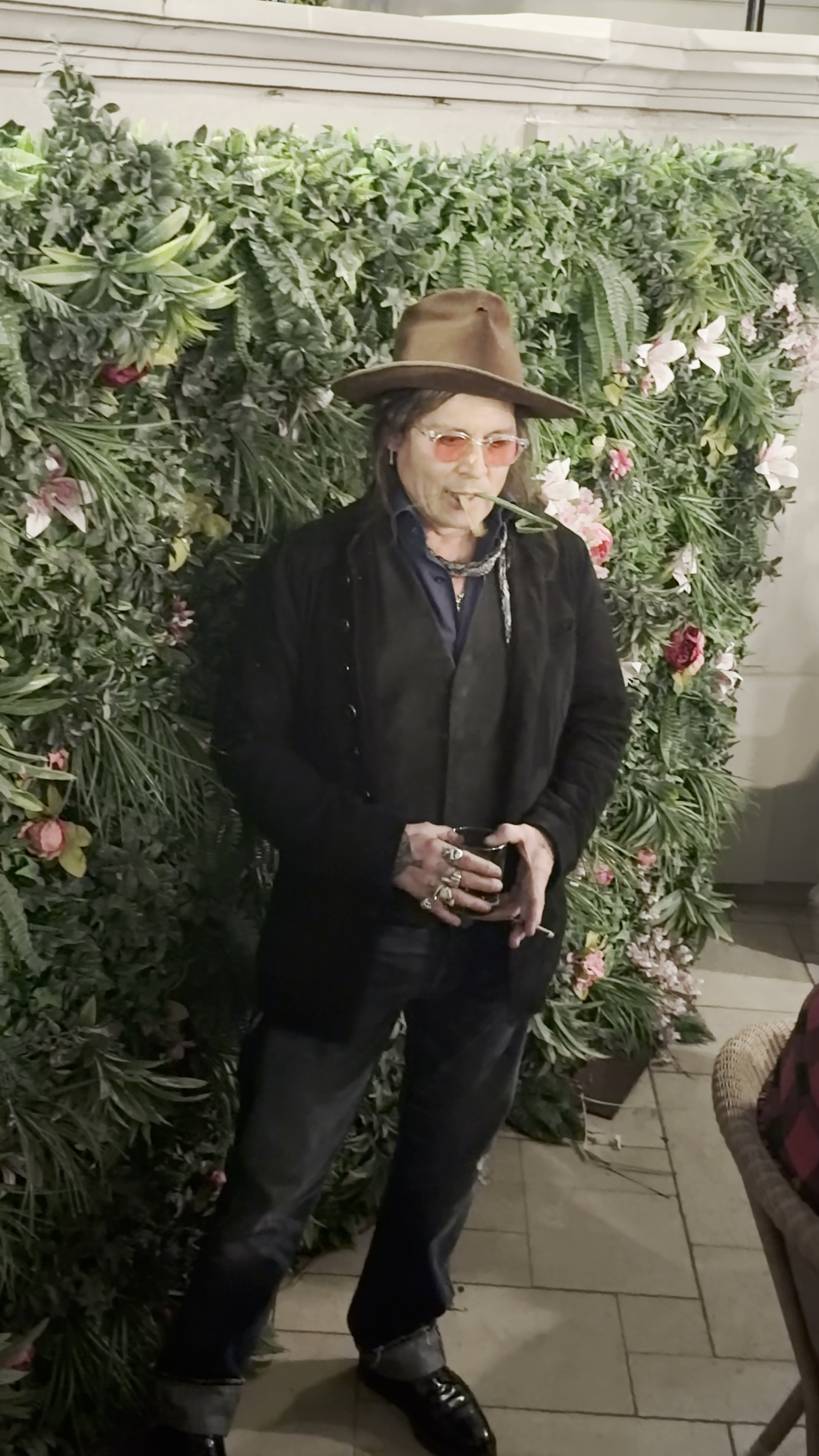 Johnny Depp eating an artificial plant from a green wall.