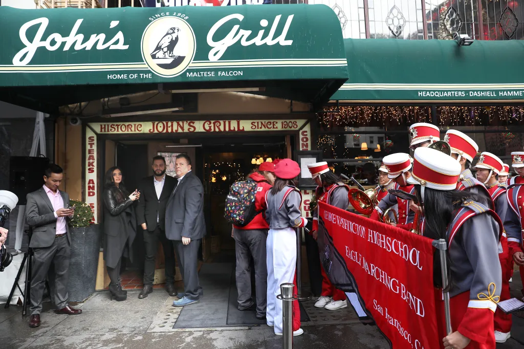John's Grill celebrating its 110th anniversary with owner John Konstin, his daughter Sydna Constin, his son John Konstin, and the George Washington High School marching band.