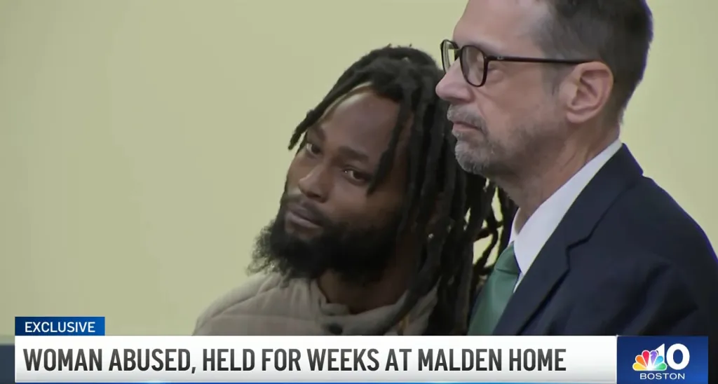 Jordende Pierre, a man with dreadlocks and a beard, next to his attorney, during court proceedings.