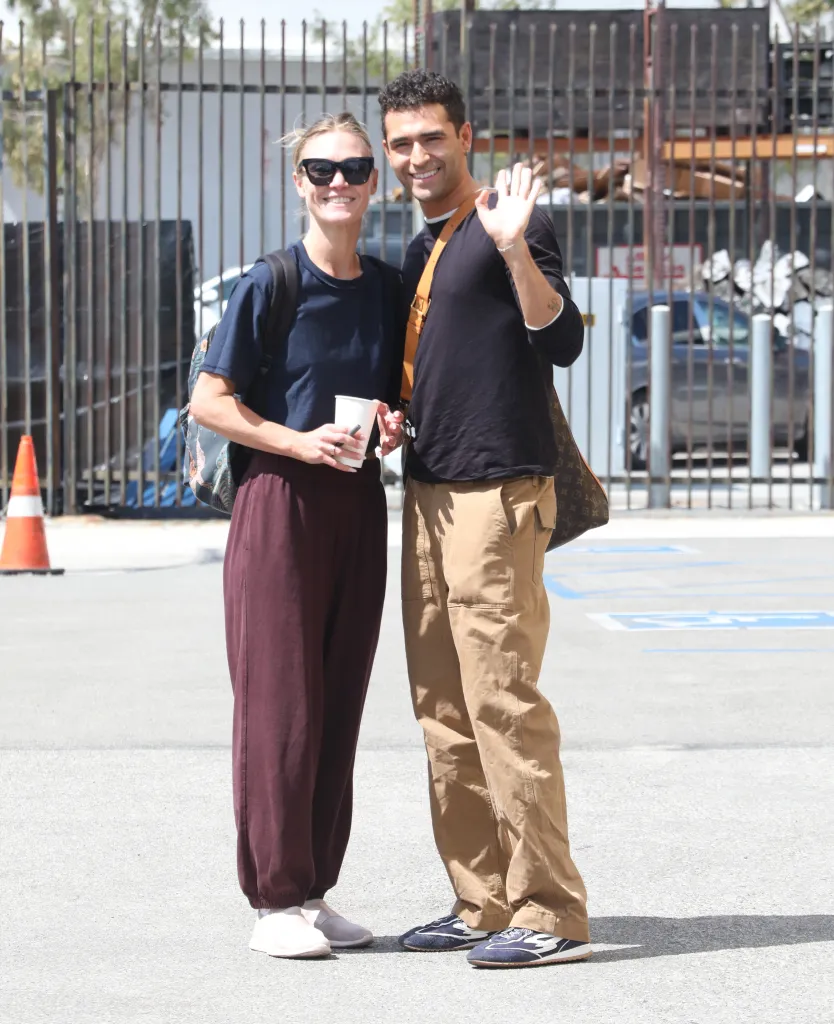 Julia Stiles and Ezra Sosa standing outside, smiling at the camera.