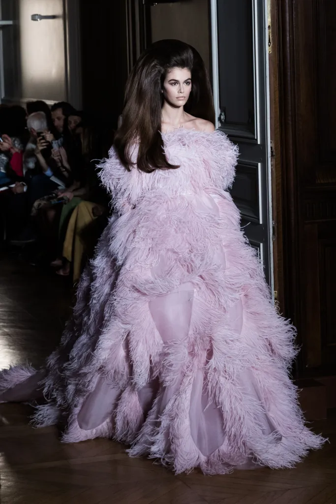Kaia Gerber in a voluminous, off-the-shoulder pink feathered gown on the Valentino runway.