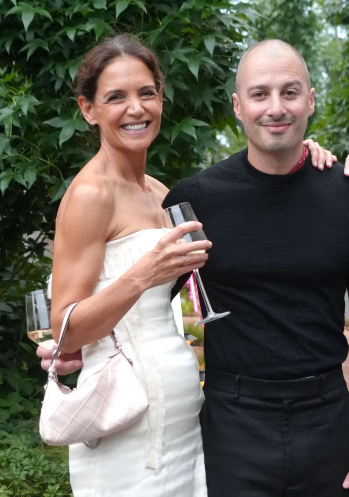 Katie Holmes in a white dress and Jason Bard Yarmosky in a black shirt smiling at the Guild Hall 2026 Summer Gala.