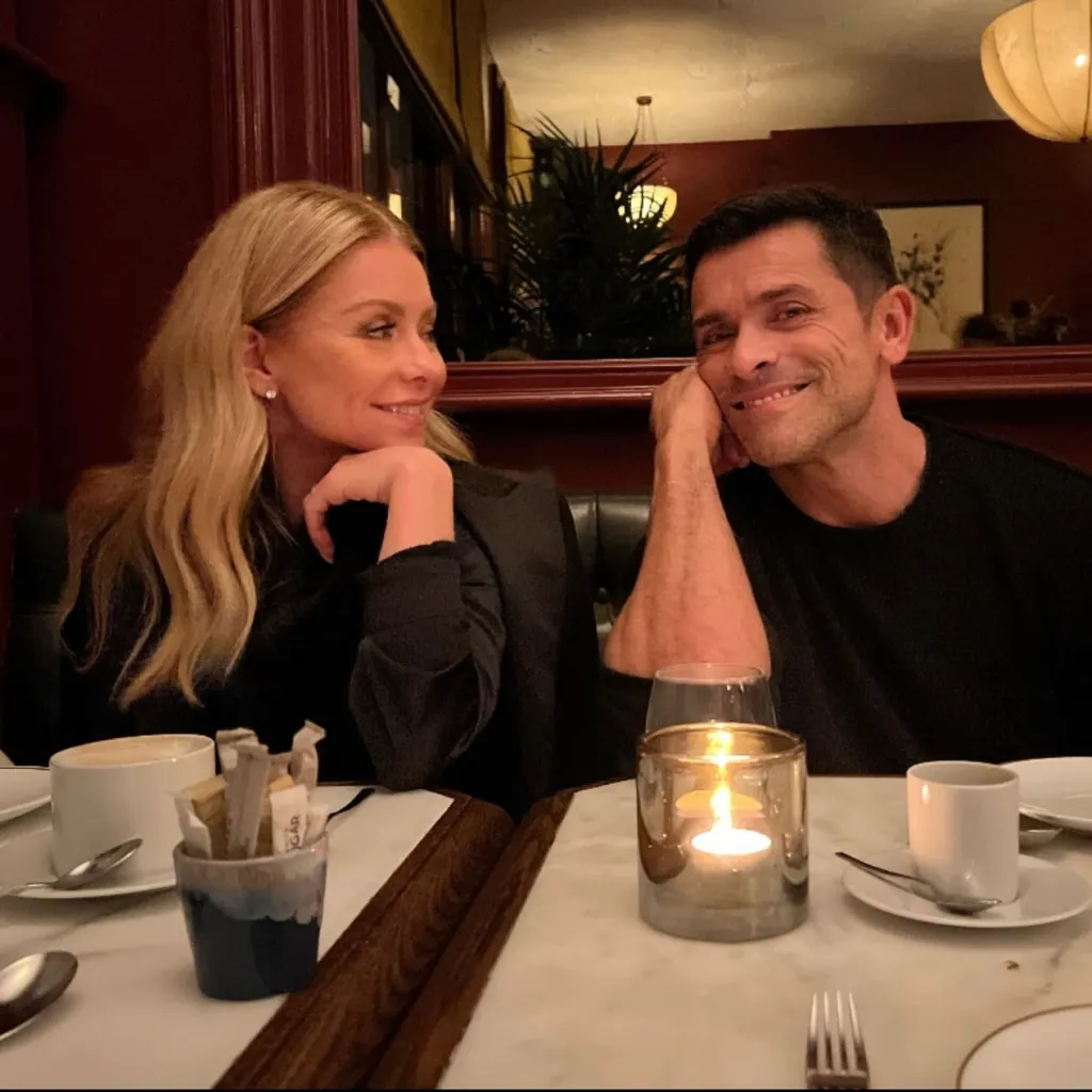 Kelly Ripa and Mark Consuelos looking at each other at a restaurant.