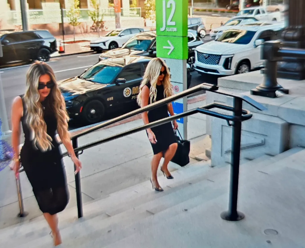 Kim Zolciak and Brianna walk up the stairs of the Fulton County Courthouse.