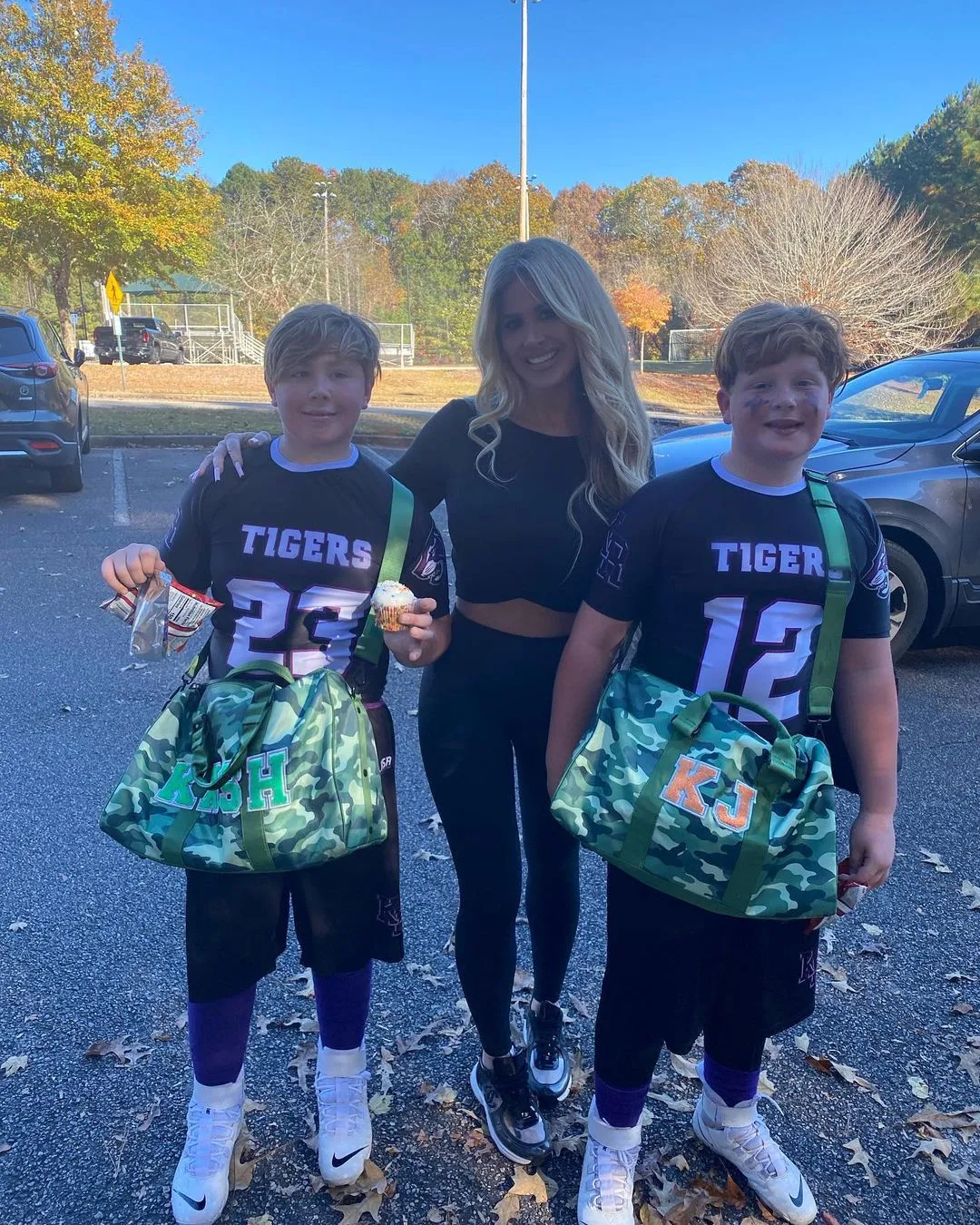 Kim Zolciak with her two sons dressed in football uniforms.