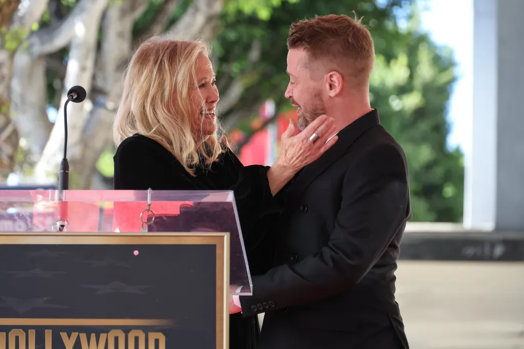 Catherine O'Hara touching Macaulay Culkin's face at the Hollywood Walk of Fame ceremony.