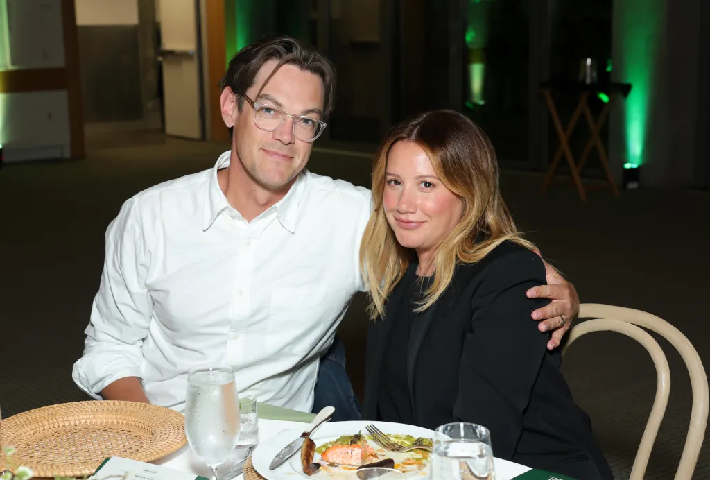Christopher French and Ashley Tisdale sitting at a table together.