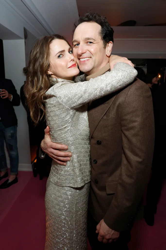 Keri Russell, in a silver skirt suit, and Matthew Rhys, in a brown suit, embracing at W Magazine's Annual Best Performances Party.