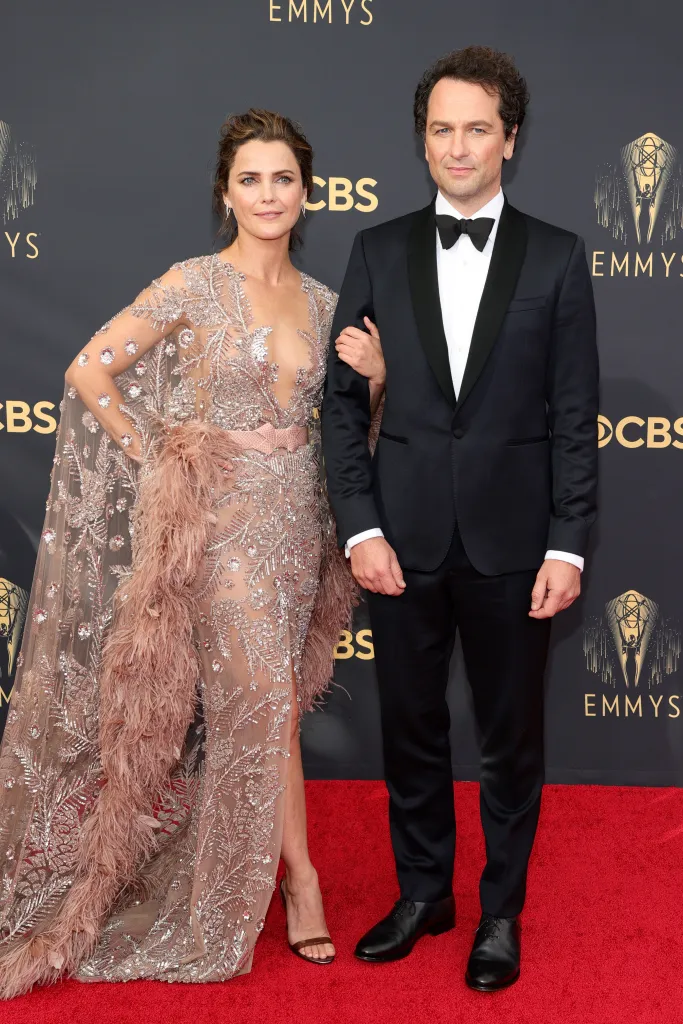 Keri Russell, In a metallic gown, and Matthew Rhys, in a black tuxedo, on the red carpett the Emmys.