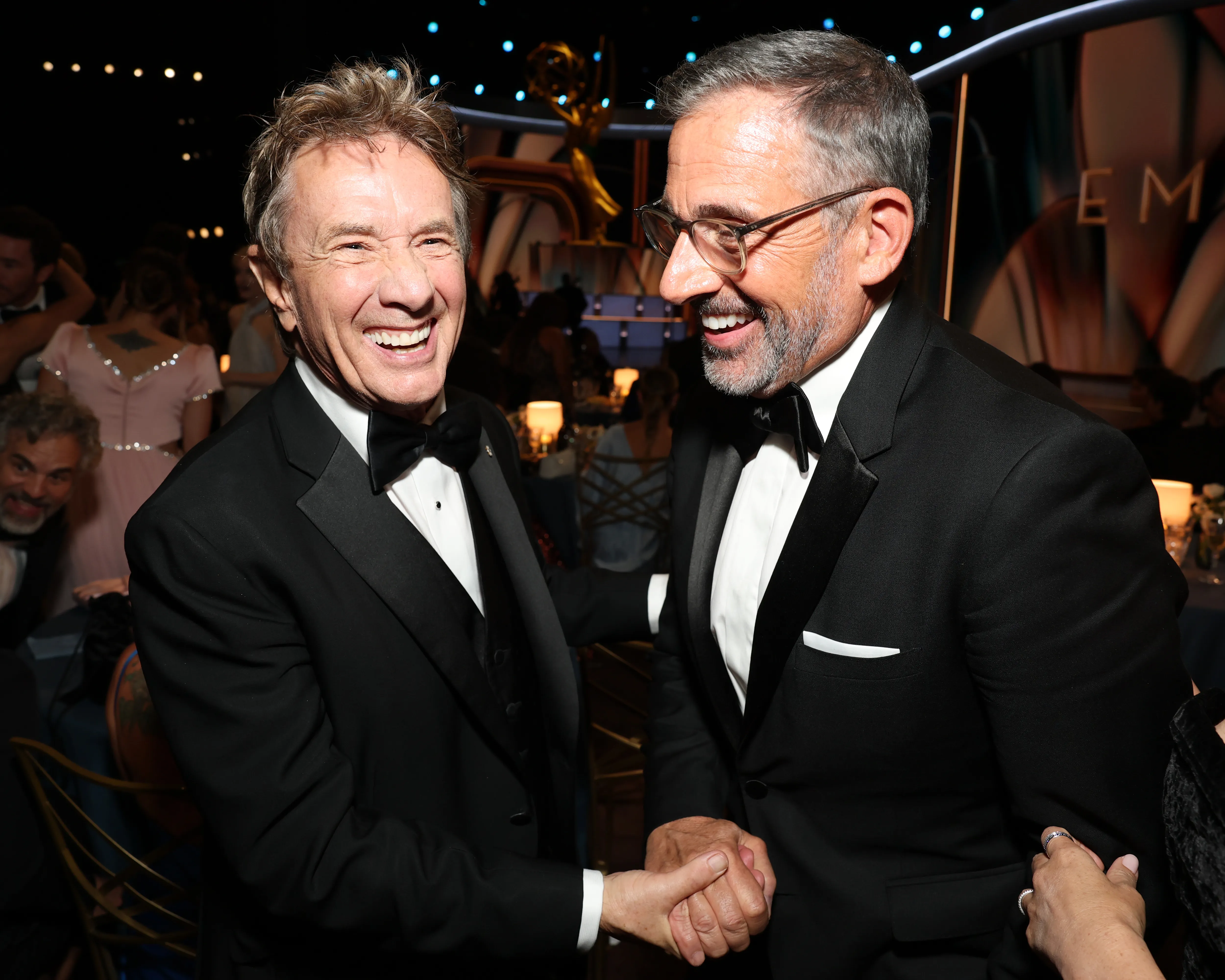 Martin Short and Steve Carell shake hands at an awards ceremony.