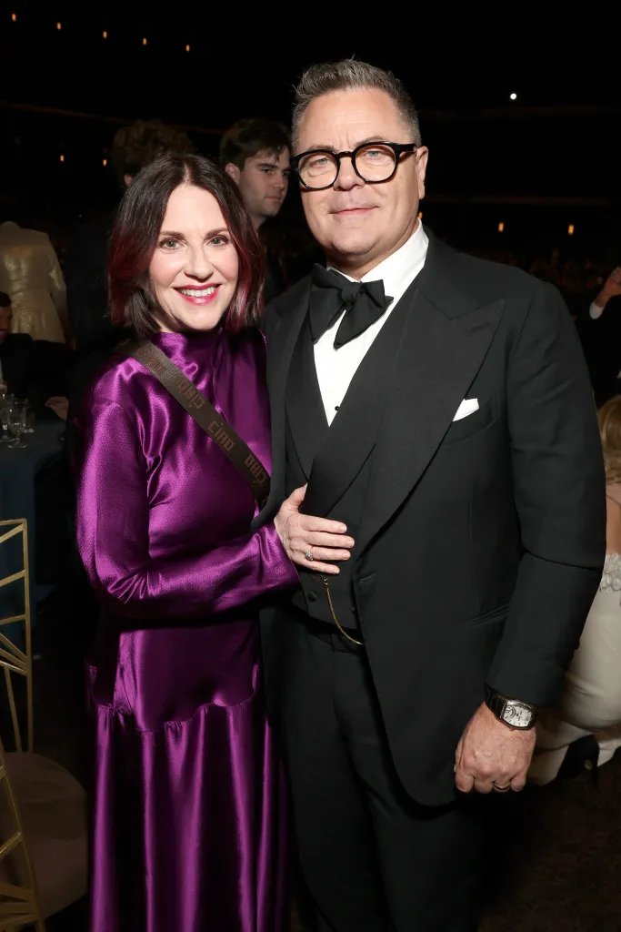 Megan Mullally in a purple dress and Nick Offerman in a tuxedo.