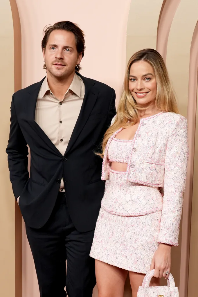 Tom Ackerley and Margot Robbie standing together.