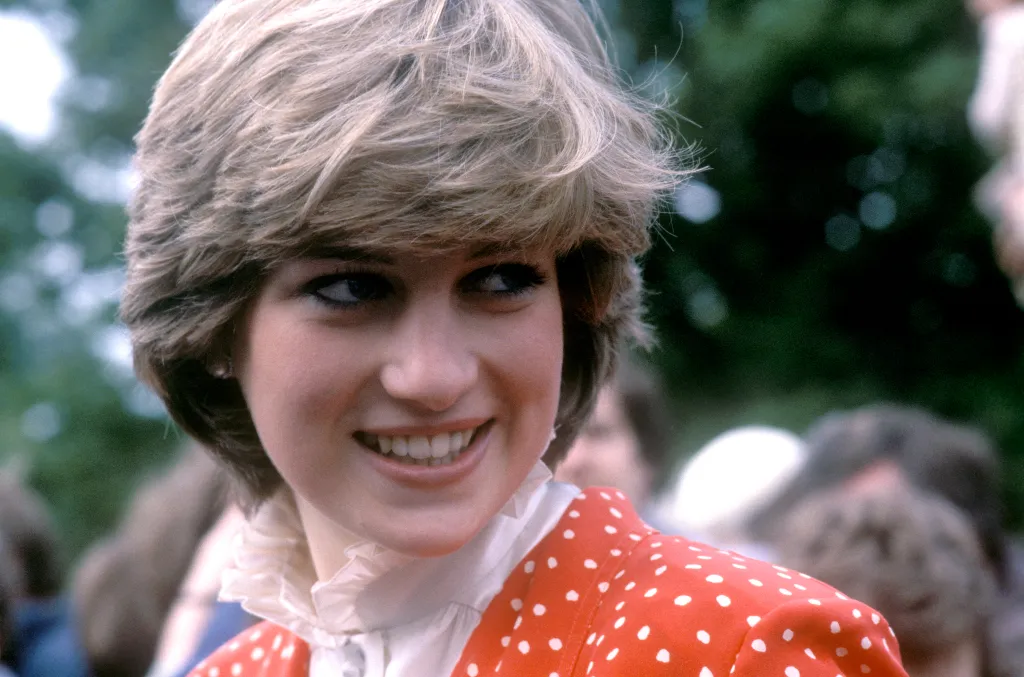 Lady Diana Spencer, the future Princess of Wales, smiling and looking to the right, wearing a red polka-dot top.