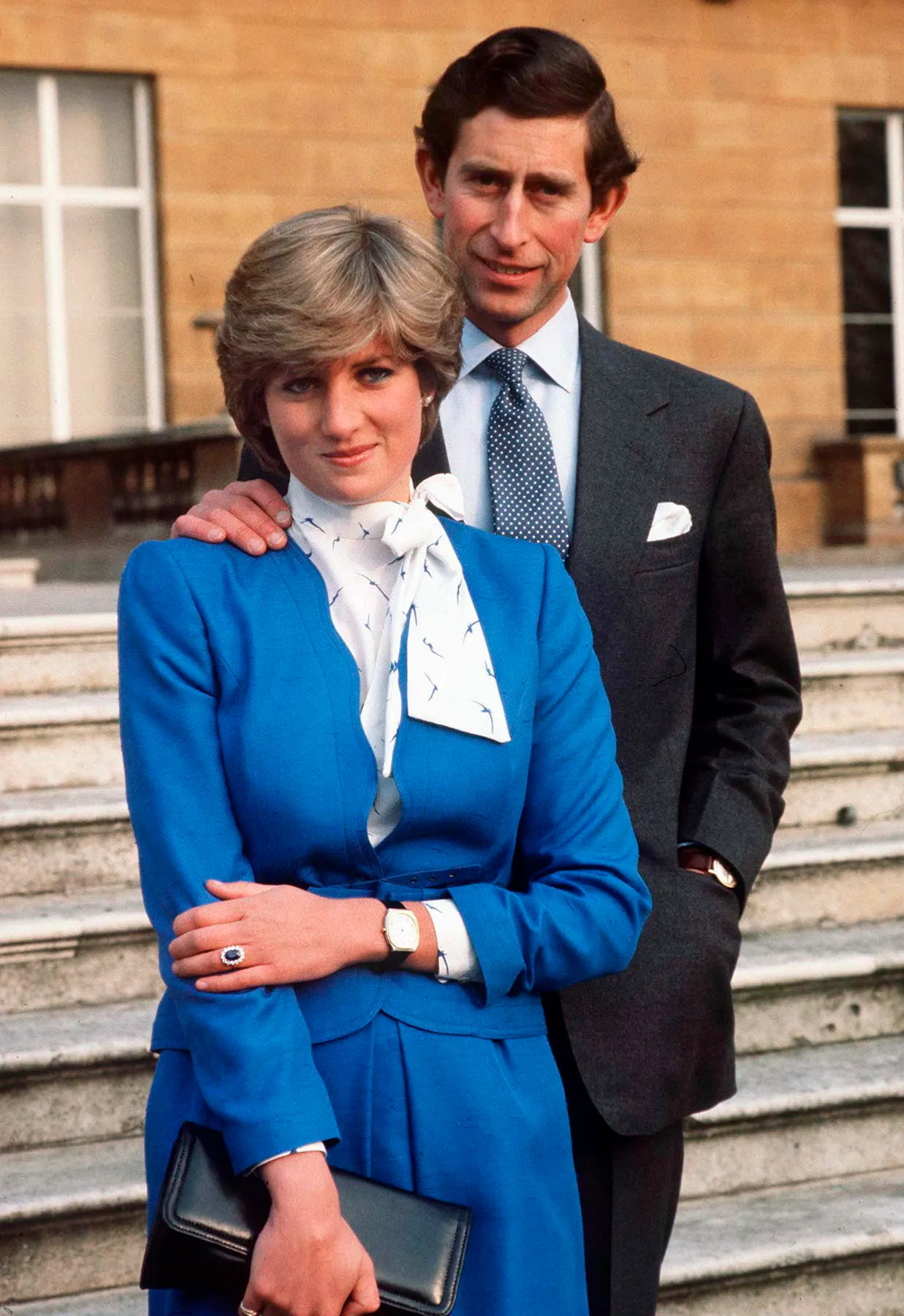 Lady Diana Spencer and Prince Charles posing for photographs, with Diana showing her sapphire and diamond engagement ring.