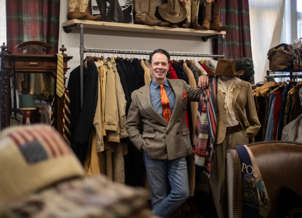 Laird McIntosh in his Ralph Lauren archive, standing in front of a clothing rack.