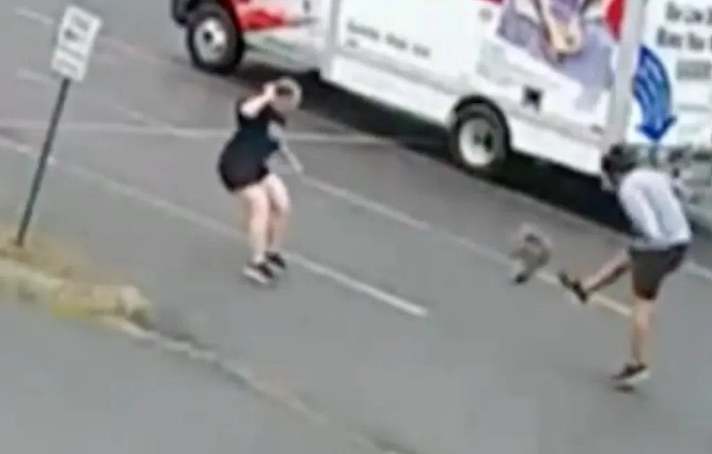 A person trying to kick away an attacking animal while another person tries to defend themselves.