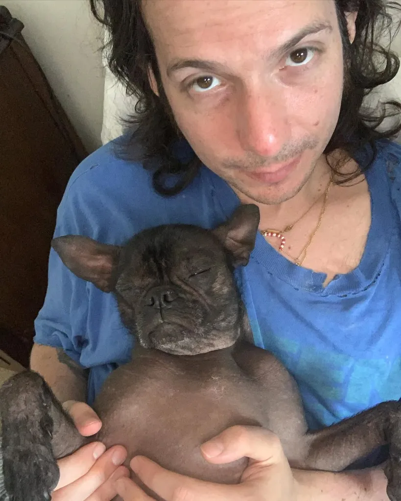 Luis Felber holding a dog with closed eyes.