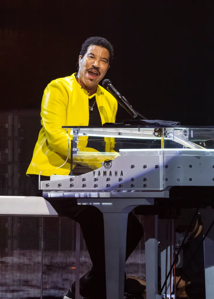 Lionel Richie performing on a white Yamaha piano.