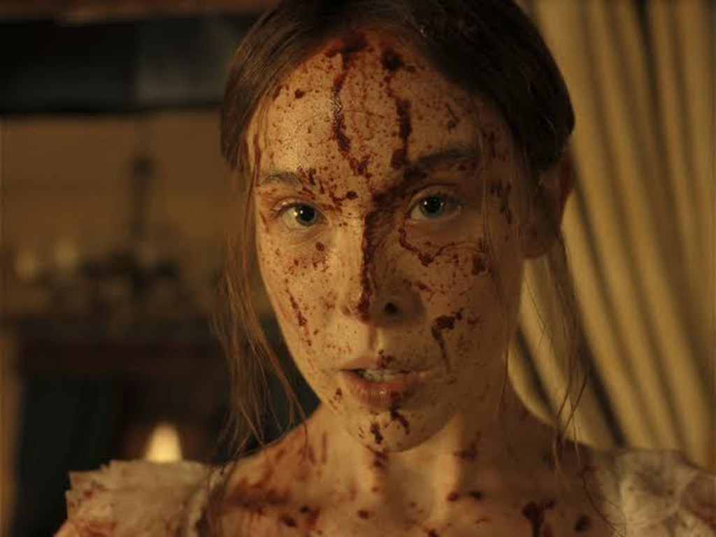Ella Beatty as Lizzie Borden, covered in blood.