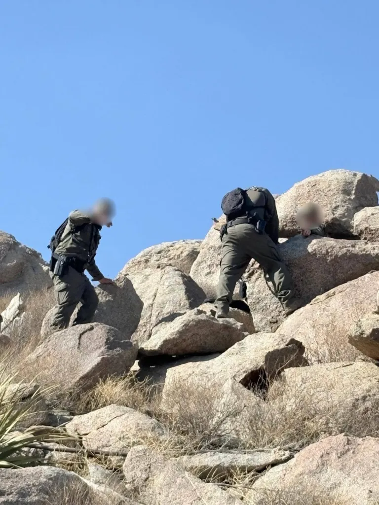 Border Patrol agents searching rugged boulder fields in the Jacumba Mountains.