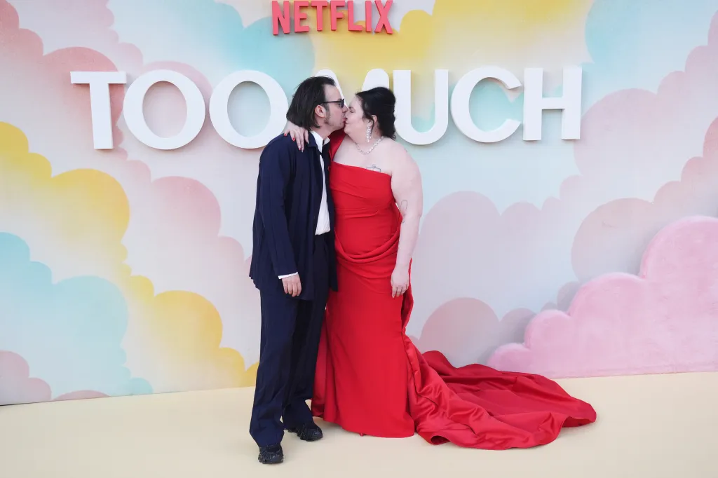 Luis Felber and Lena Dunham kiss in front of a