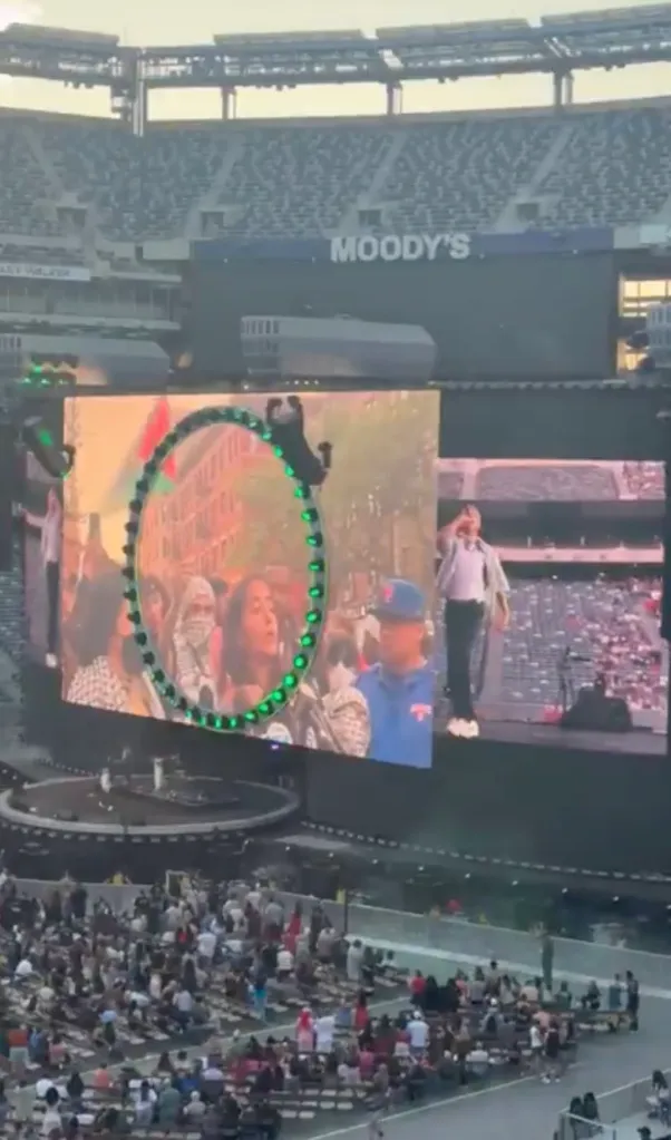 Macklemore performing at MetLife Stadium, with a large screen displaying images related to Palestine.