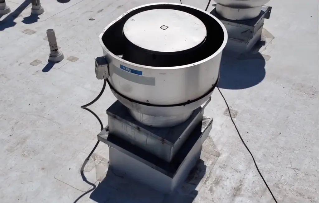A large silver exhaust vent on a white rooftop.