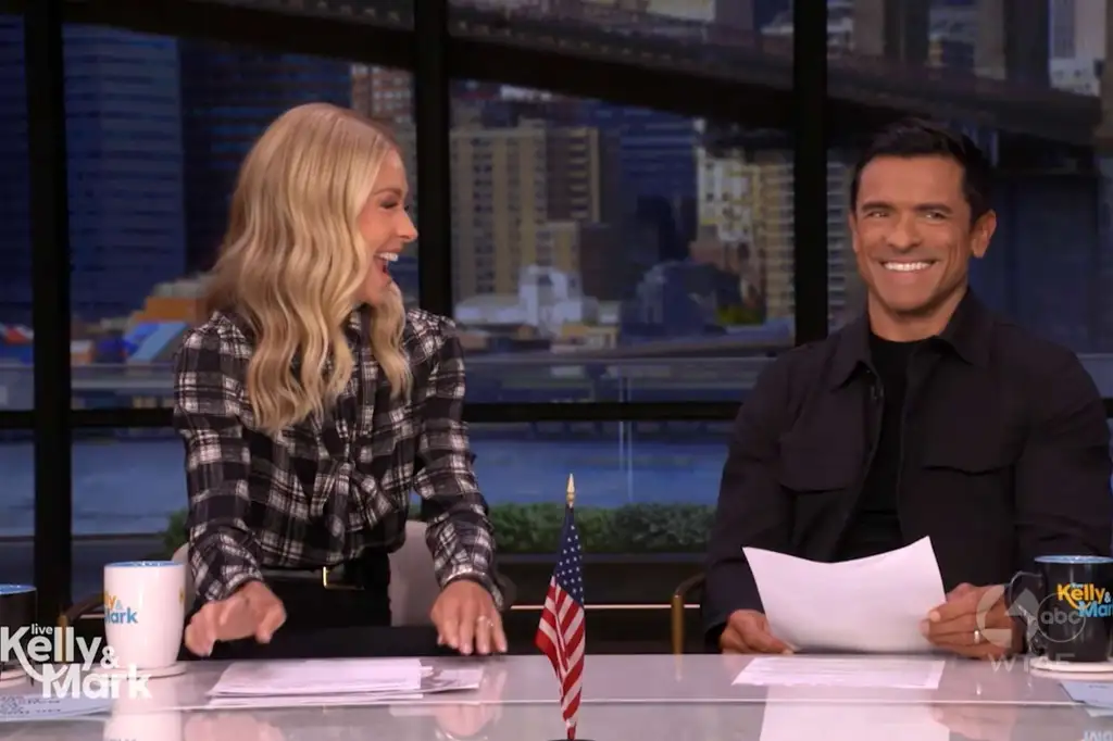 Kelly Ripa and Mark Consuelos smiling at their show 