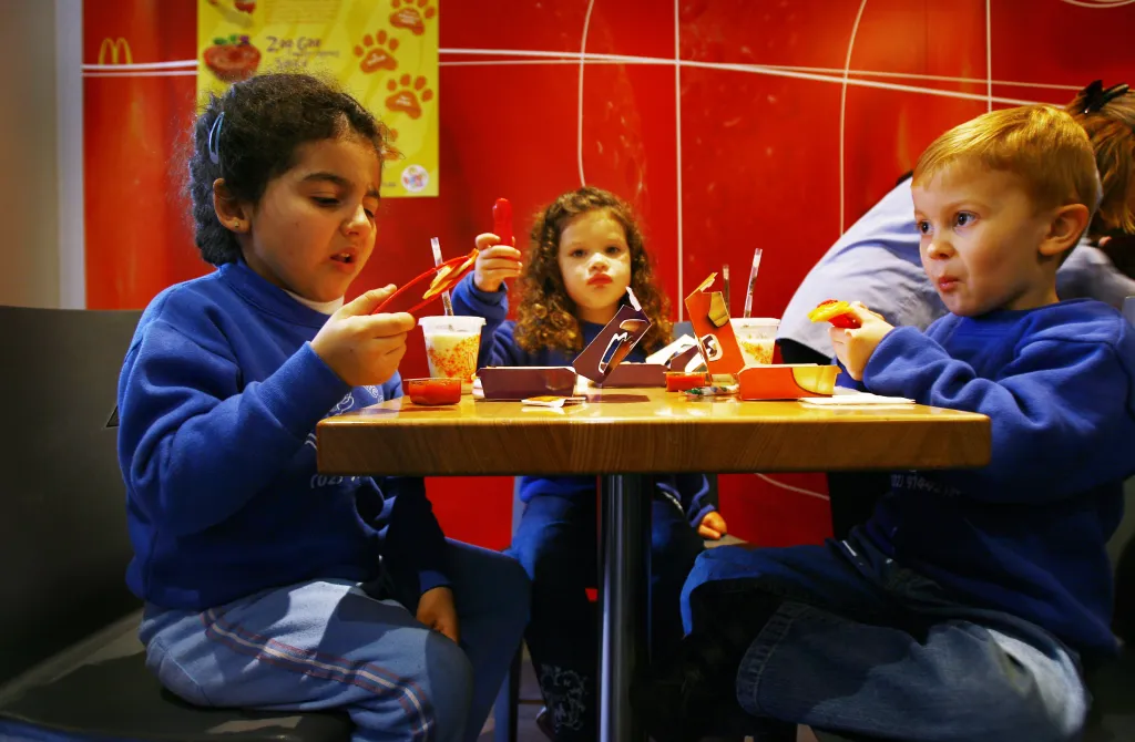 Three young children, Jamie, Isabella, and Mark, trying out the new Pasta Zoo menu at a McDonald's restaurant.