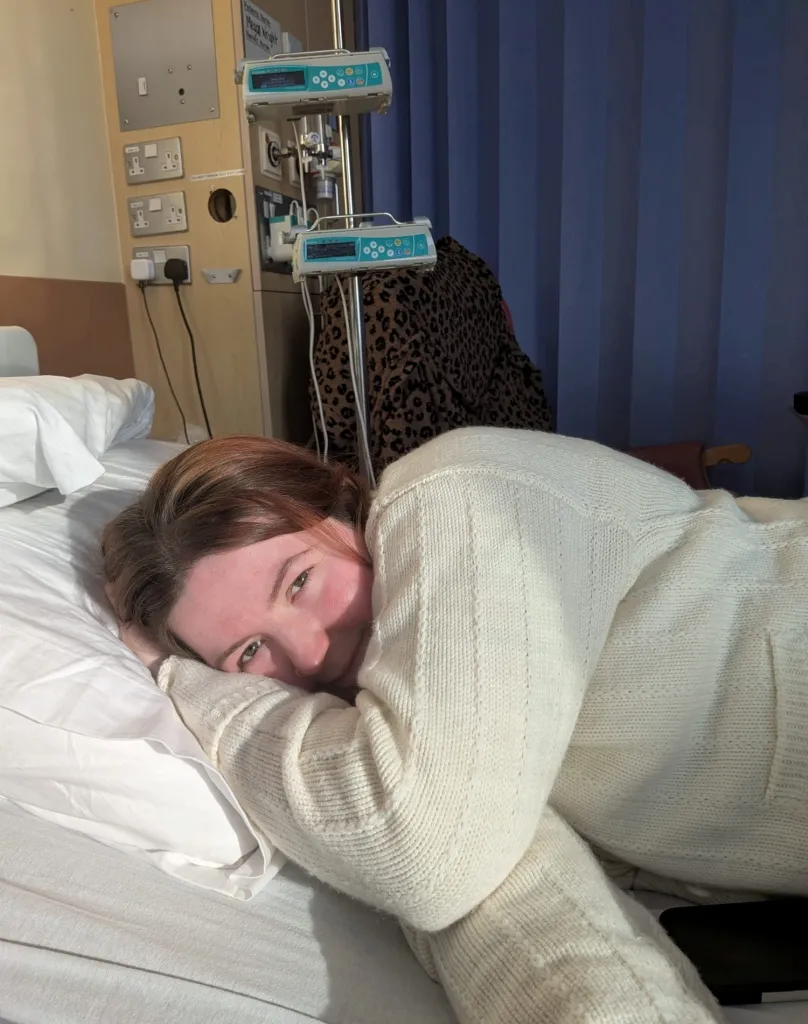 Megan Wright, 28, lying in a hospital bed, looking at the camera.