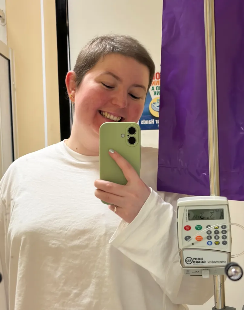 Megan Wright smiling while taking a mirror selfie in a hospital.