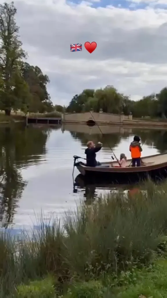 Prince Harry and his two children in a boat on a lake.