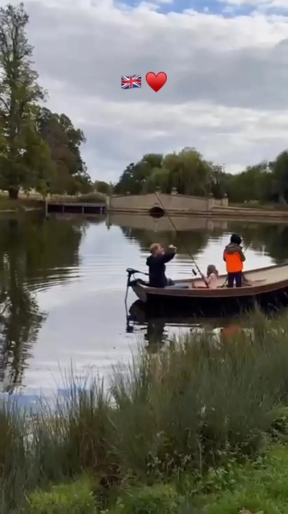Meghan Markle and Prince Harry with two children in a boat on a lake.