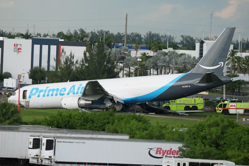 An Amazon Prime Air cargo plane, with a damaged wing, off the runway.