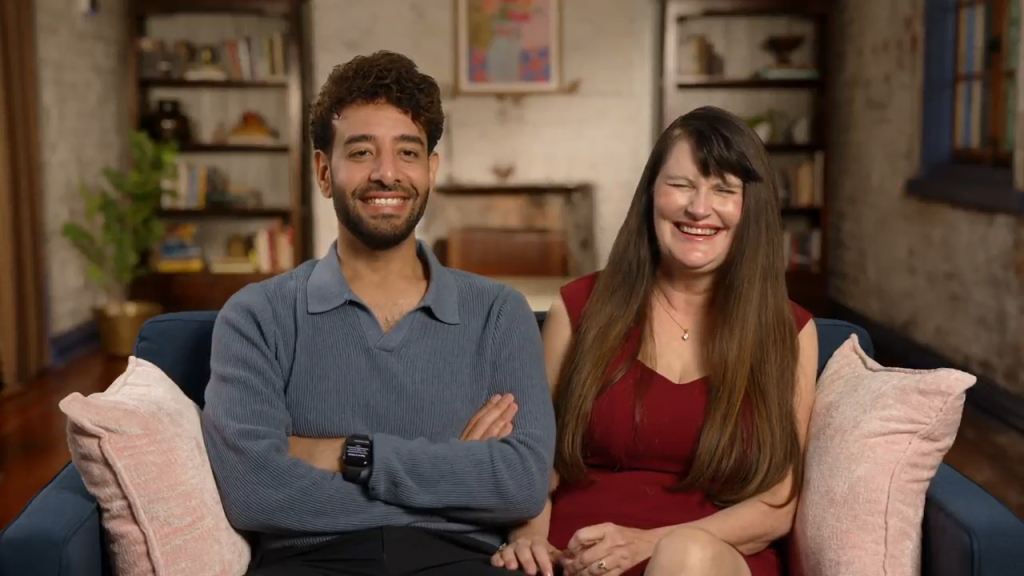 Mido and Debby sitting on a couch, Mido smiling and Debby laughing.