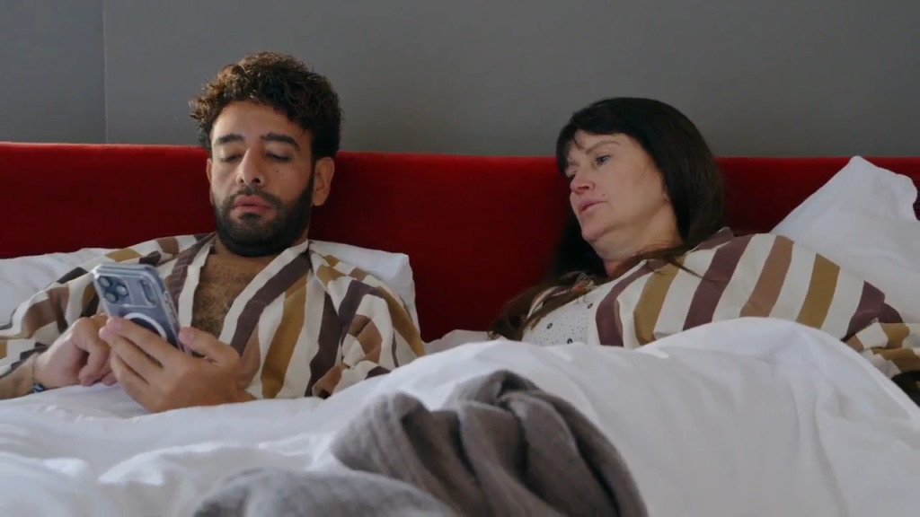Mido looking at his phone while Debby looks at him with a disappointed face.
