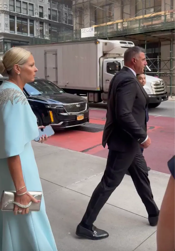 Mike Vrabel and Jen Vrabel walking down a city street.