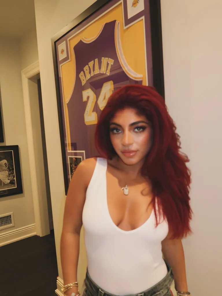 Milania Giudice posing in front of a framed Kobe Bryant Lakers jersey.